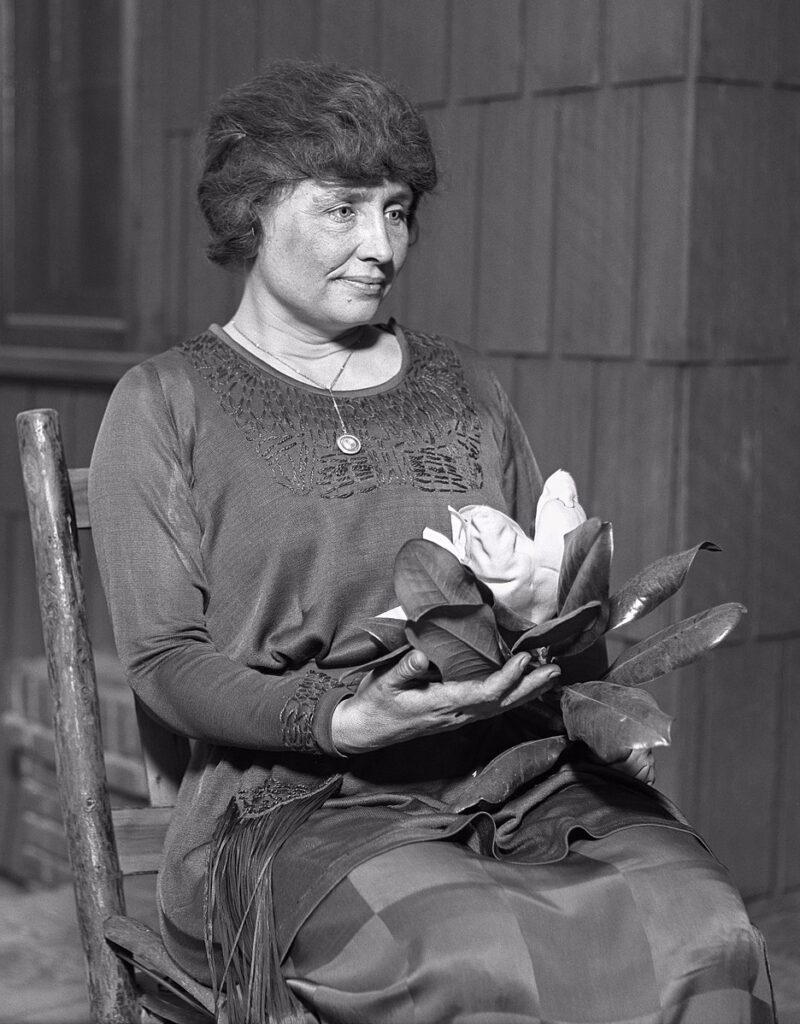 Helen Keller sitting in chair.