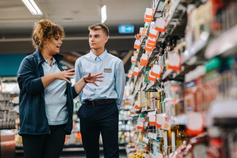 Store incharge training young worker. Supermarket manager giving training to a trainee.- best jobs without a college degree