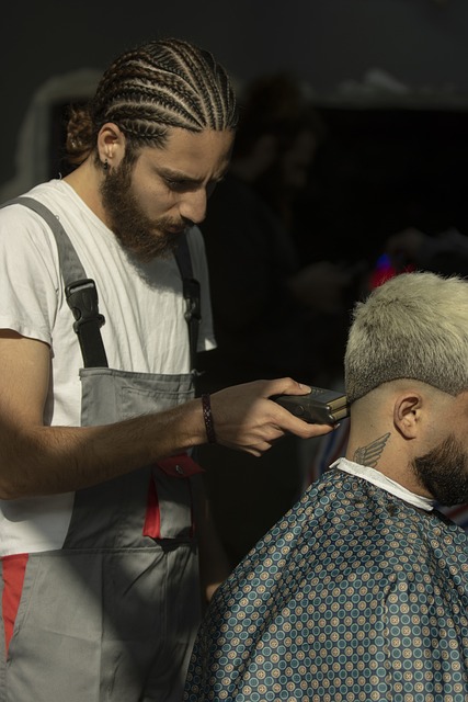 A barber uses an electric razor to cut a man's hair