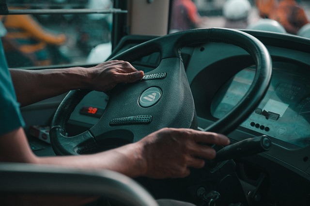 Closeup of a person's hands driving a large bus steering wheel- best jobs without a college degree