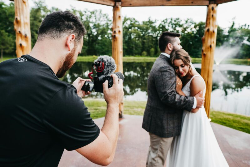 A photographer takes a photo of a bride and groom outdoors- best jobs without a college degree