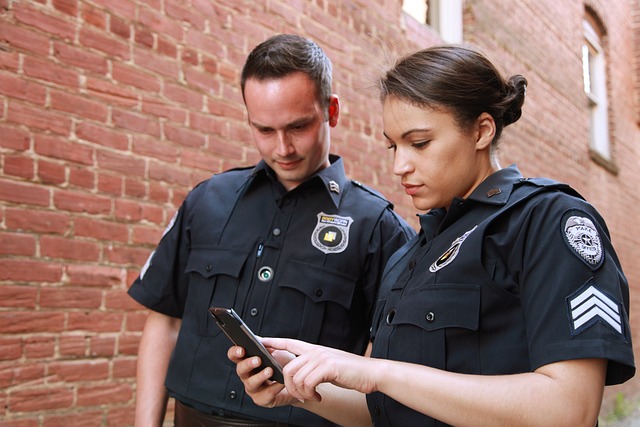 Two police officers look at a phone together- best jobs without a college degree